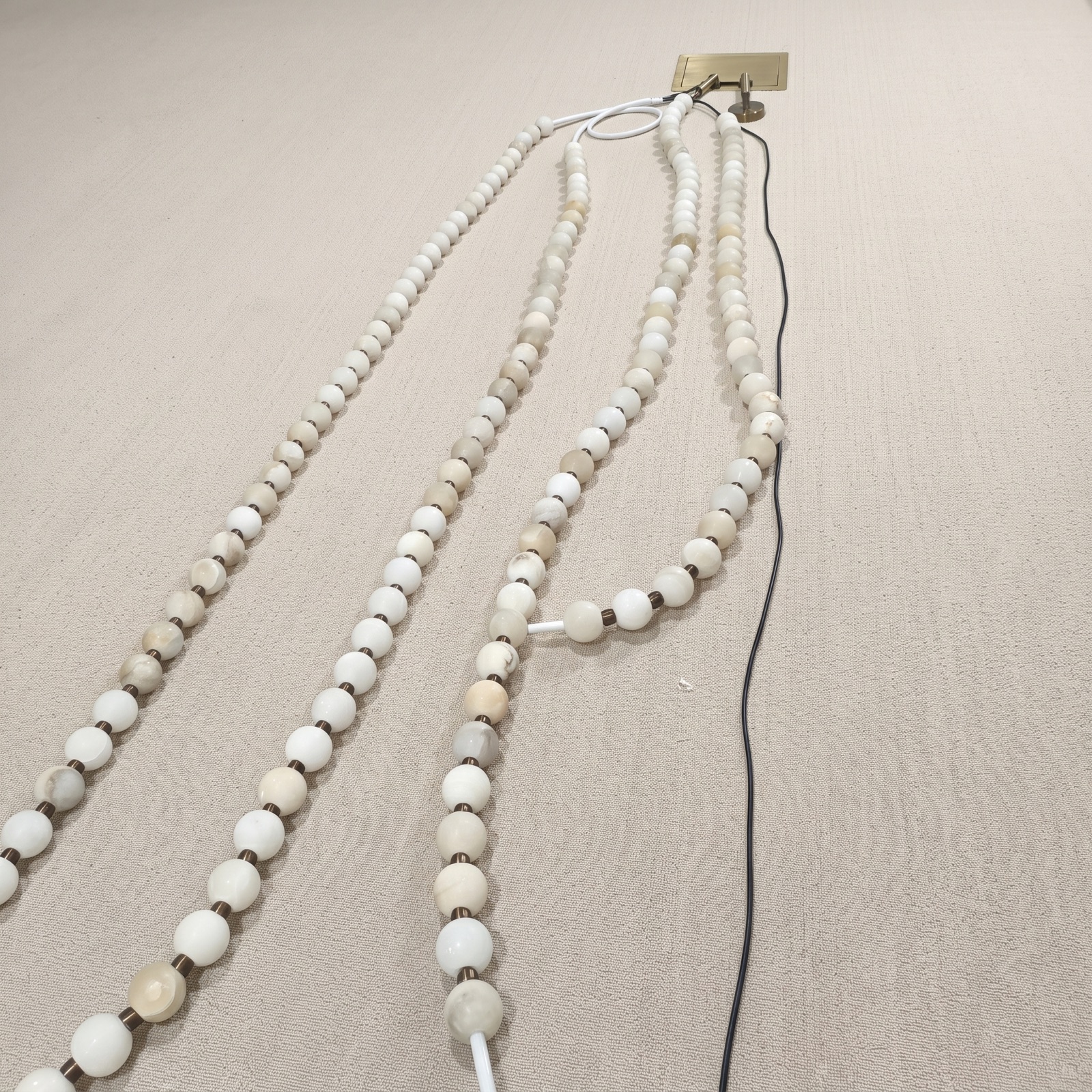 Alabaster sphere strands laid out during chandelier assembly